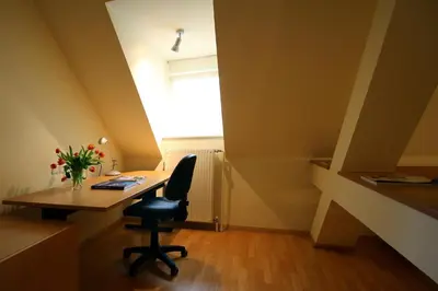 an office with a desk and a chair and a window at Apartments Villa Boltez in Kranj