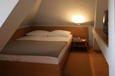a bed in a small room with a lamp at Apartments Villa Boltez in Kranj