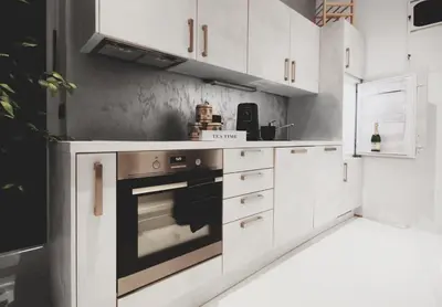 a kitchen with white cabinets and an oven at CASA GLITTER in Ljubljana