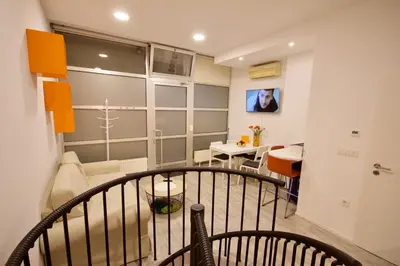 a room with a balcony with a living room and a table at Albina apartment in Ljubljana