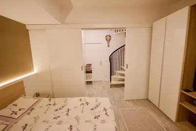 a room with a bed and a hallway with a staircase at Albina apartment in Ljubljana