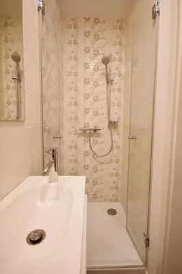 a white bathroom with a shower and a sink at Albina apartment in Ljubljana