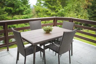 a wooden table with four chairs on a deck at Apartma Smučka pod Roglo in Zreče