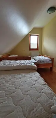 a bedroom with two beds and a window at Apartma Smučka pod Roglo in Zreče