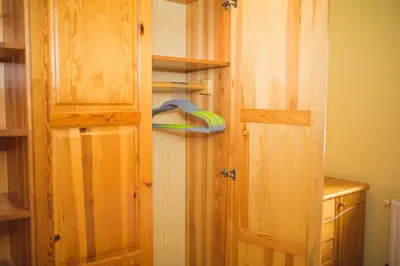 a closet with a wooden door and a hanger at Apartma Smučka pod Roglo in Zreče