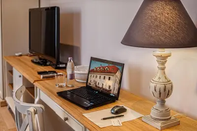 a laptop computer sitting on a desk with a lamp at B&B Dvor Tacen in Ljubljana