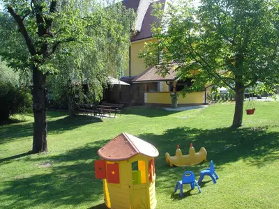 a childs play house in the grass with two toys at Guest House Čater in Laško
