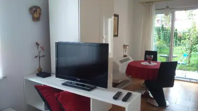 a living room with a large television on a white table at Vila Ema Apartments and Rooms in Ljubljana