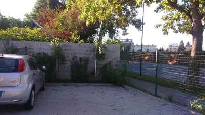 a car parked in a parking lot next to a fence at Vila Ema Apartments and Rooms in Ljubljana