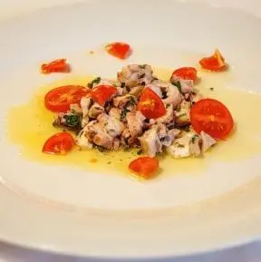 a white plate of food with tomatoes on it at Guest House pri Vodniku in Ljubljana