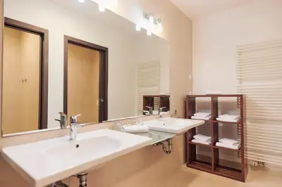a bathroom with two sinks and a large mirror at Hotel Meksiko in Ljubljana