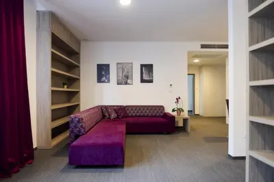 a living room with a purple couch and shelves at Hotel Meksiko in Ljubljana