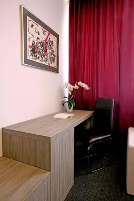 a desk in a room with a red curtain at Hotel Meksiko in Ljubljana