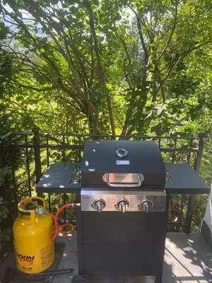 a grill sitting next to a table with a yellow bucket at Entire house Iris & Arnika in Bled