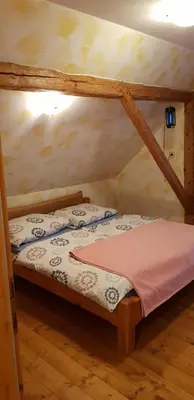 a small bedroom with a bed in a attic at Apartments Za Grapo in Cerkno