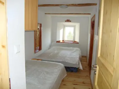 a small bedroom with two beds and a window at Apartments Za Grapo in Cerkno