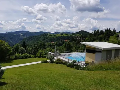 a house with a swimming pool in a field at Apartments Za Grapo in Cerkno