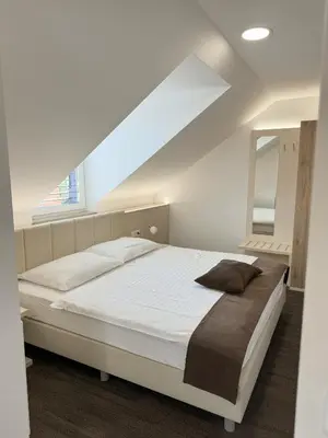 a bedroom with a white bed and a window at Hiša Aleš in Kranj