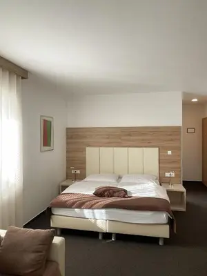 a bedroom with a large bed with a wooden headboard at Hiša Aleš in Kranj