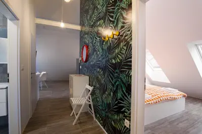 a bedroom with a wall mural of leaves at Flex Apartments Tour As Ljubljana in Ljubljana