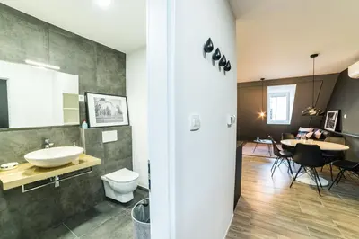 a bathroom with a sink and a toilet and a table at Flex Apartments Tour As Ljubljana in Ljubljana