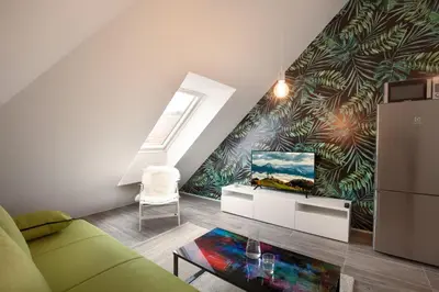 a living room with a green couch and a mural at Flex Apartments Tour As Ljubljana in Ljubljana