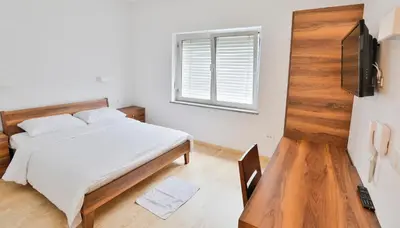 a bedroom with a bed and a window at Prenočišča Kogoj in Miren