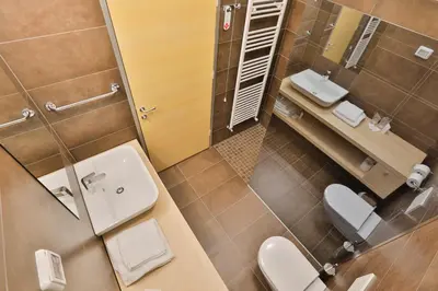 a bathroom with two toilets and a sink and a mirror at Prenočišča Kogoj in Miren