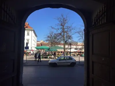 an archway with a white car parked in a street at Harmony Gallery in Ljubljana