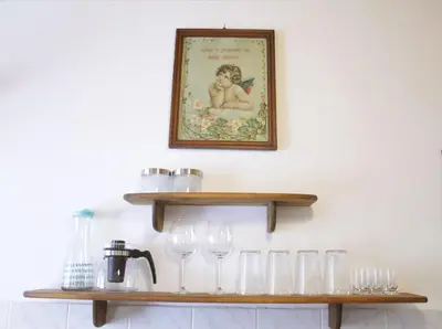 a shelf with wine glasses and a picture on the wall at Harmony Gallery in Ljubljana