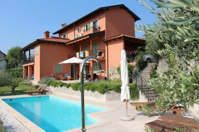 a villa with a swimming pool in front of a house at Zoi Apartments in Dobrovo