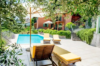 a patio with chairs and a table and a pool at Zoi Apartments in Dobrovo