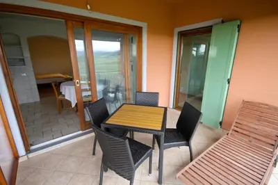 a table and chairs on a balcony with a table at Zoi Apartments in Dobrovo
