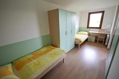 a bedroom with two beds and a cabinet and a desk at Zoi Apartments in Dobrovo