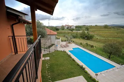 a view of a swimming pool from a balcony of a house at Zoi Apartments in Dobrovo