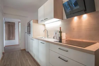 a kitchen with white cabinets and a sink at River View Apartment in Ljubljana