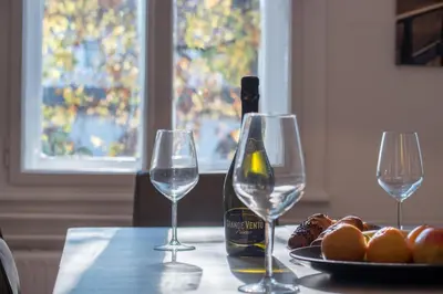 a table with two wine glasses and a bottle of wine at River View Apartment in Ljubljana