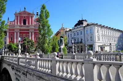 a bridge over a river in a city with buildings at River View Apartment in Ljubljana