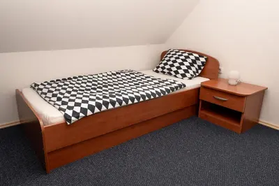 a bed with black and white checkered pillows on it at Apartmajske hiške Lubadarček in Podčetrtek