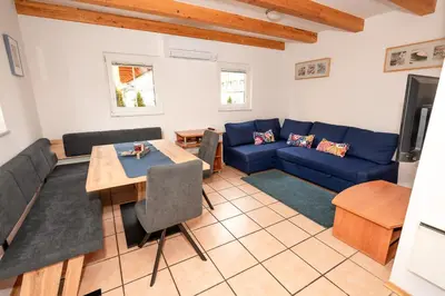 a living room with a blue couch and a table at Apartmajske hiške Lubadarček in Podčetrtek