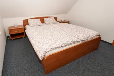 a bedroom with a wooden bed with two night stands at Apartmajske hiške Lubadarček in Podčetrtek