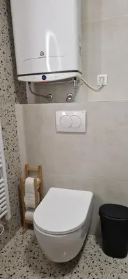 a white toilet in a bathroom with aperature at Apartmajske hiške Lubadarček in Podčetrtek