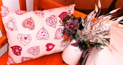 a couple of pillows sitting on a table with flowers at APARTMENT CHALET -BOHINJ- Pokljuka- Triglav National Park in Koprivnik v Bohinju