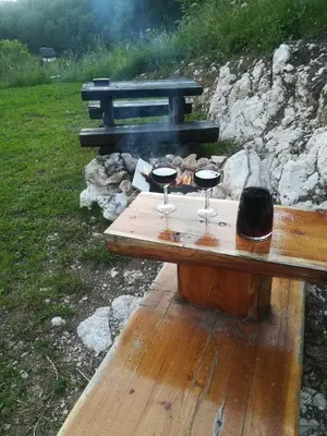 a wooden table with two glasses of wine on top at APARTMENT CHALET -BOHINJ- Pokljuka- Triglav National Park in Koprivnik v Bohinju