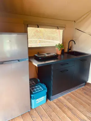 a small kitchen with a sink and a refrigerator at GreenValleyGlamping in Šešče pri Preboldu