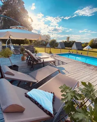 a deck with lounge chairs and a swimming pool at GreenValleyGlamping in Šešče pri Preboldu