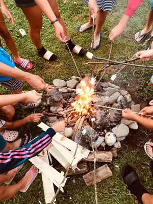 a group of people standing around a campfire at GreenValleyGlamping in Šešče pri Preboldu