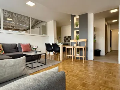 a living room with a couch and a table at Apartments Park Šiška Ljubljana in Ljubljana