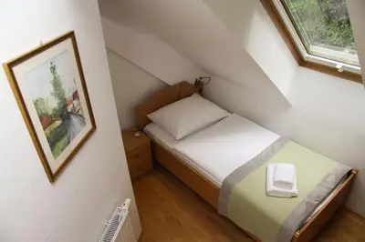 a small bedroom with a bed and a window at B&B Pod Skalo in Kamnik