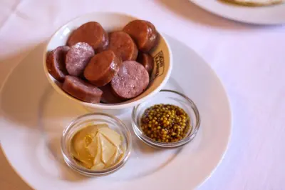 a white plate with a bowl of donuts and other ingredients at B&B Pod Skalo in Kamnik